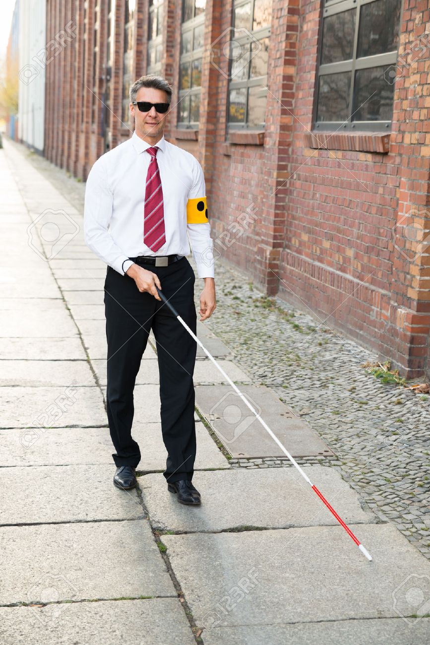 35462488-blind-man-walking-on-sidewalk-holding-stick-wearing-armband.jpg
