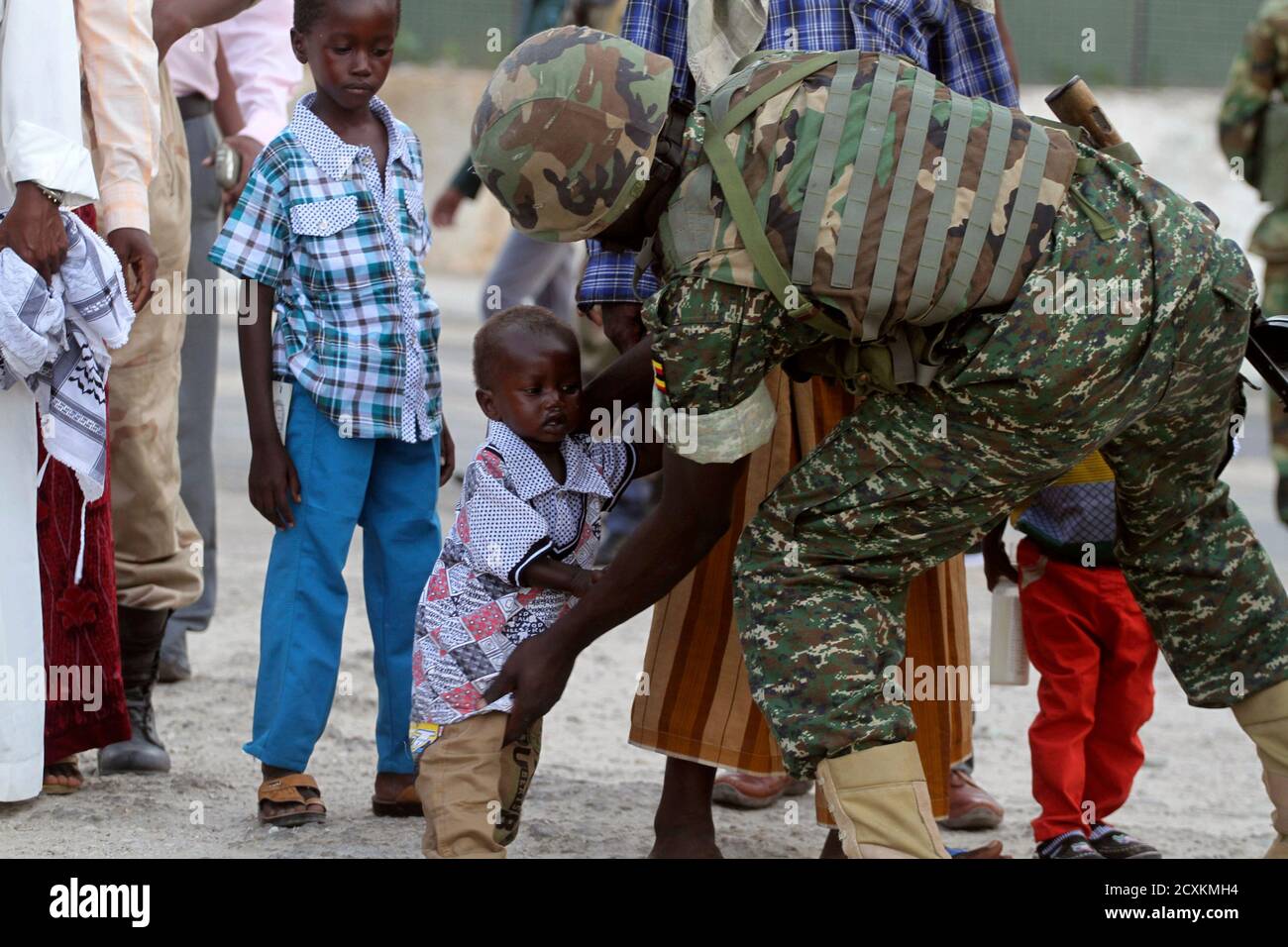 a-soldier-serving-in-the-african-union-mission-in-somalia-amisom-frisks-a-muslim-child-before-...jpg