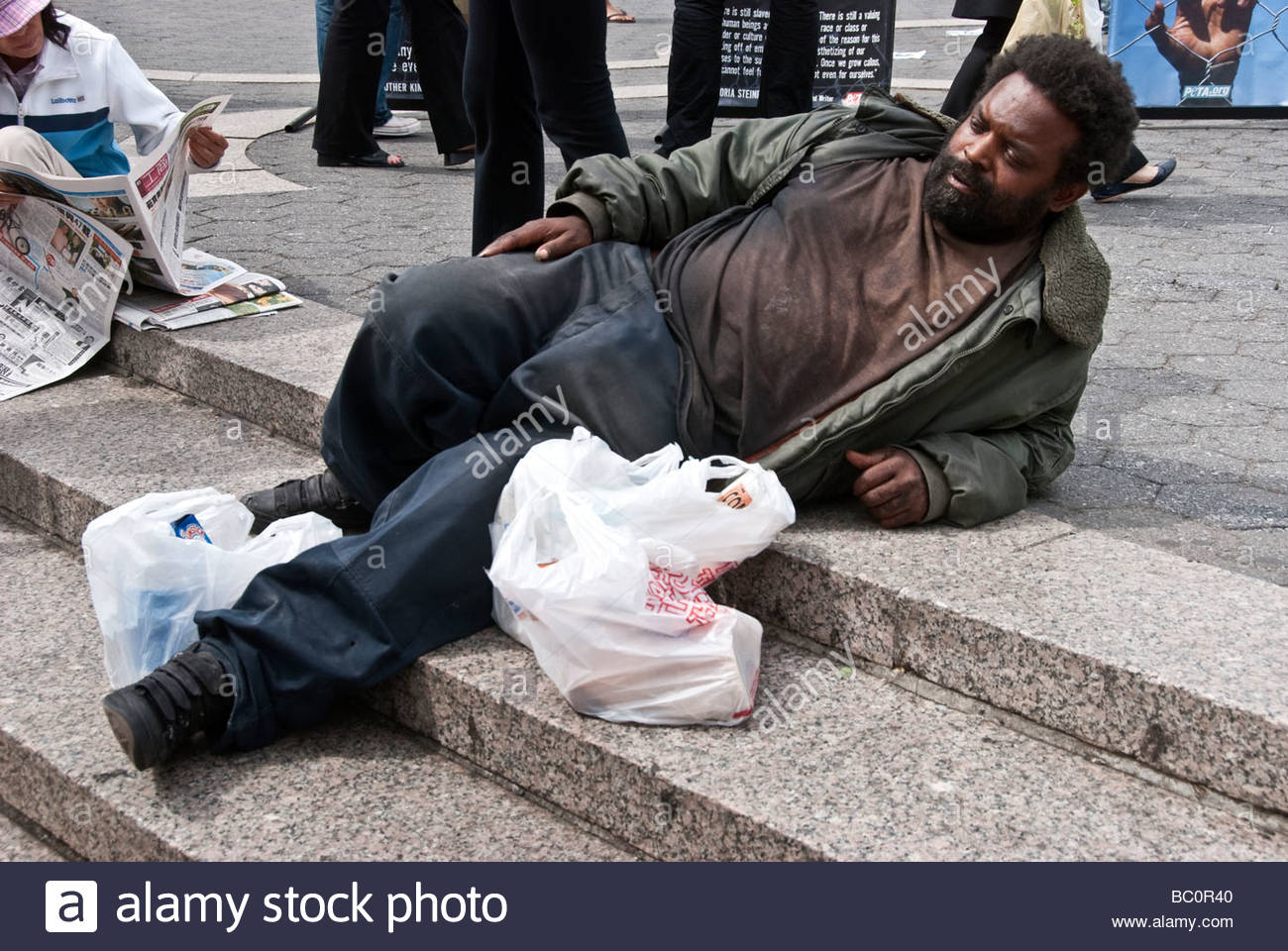 homeless-black-man-in-dirty-clothing-relaxes-peacefully-sunwarmed-BC0R40.jpg