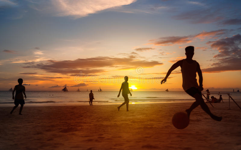 sunset-silhouettes-playing-beach-football-kick-ups-soccer-ball-55661742.jpg