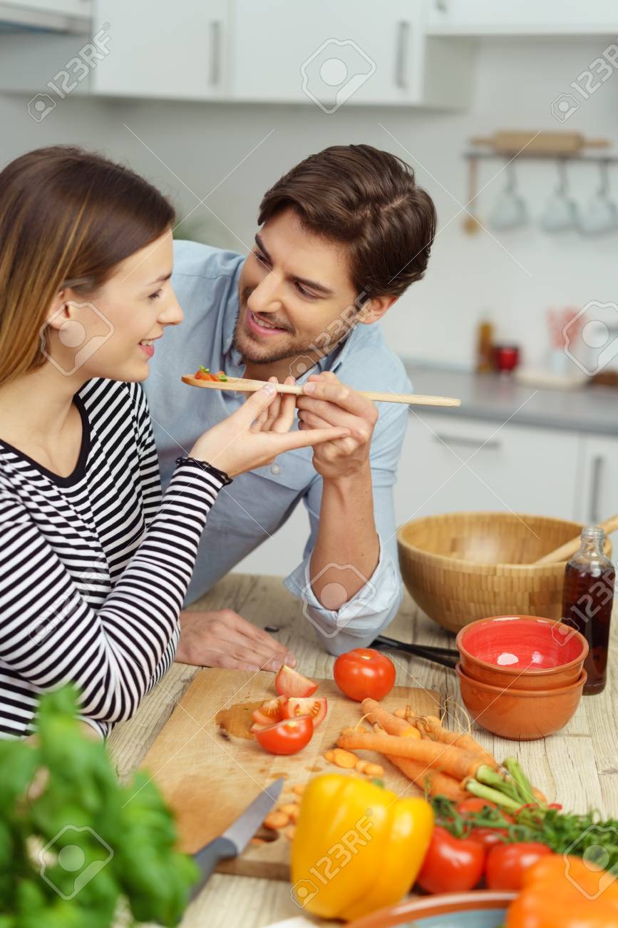 77243261-husband-and-wife-cooking-together-in-the-kitchen-with-healthy-fresh-ingredients-as-the-man-offers-th.jpg