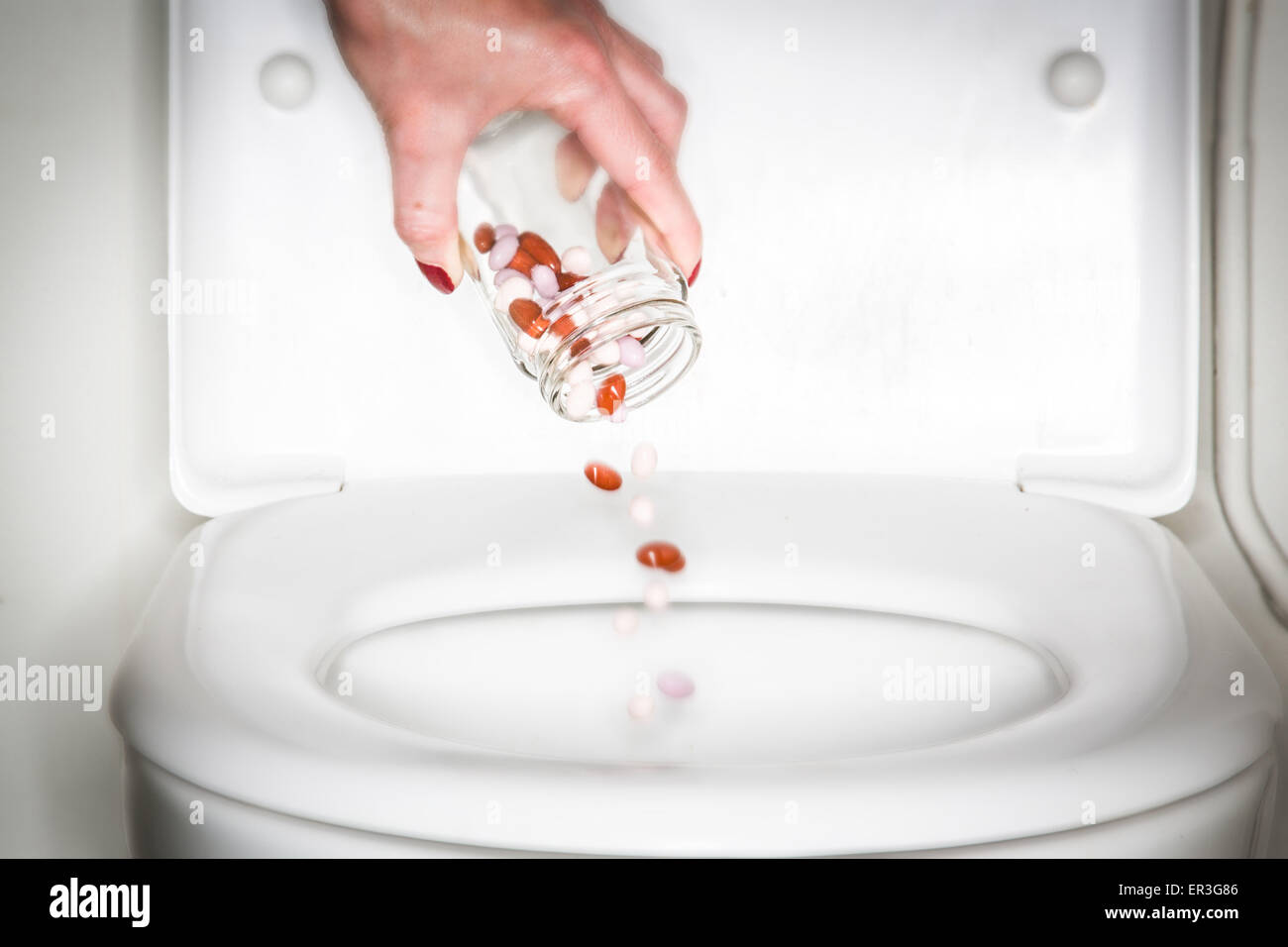 hand-throwing-pills-down-a-toilet-ER3G86.jpg