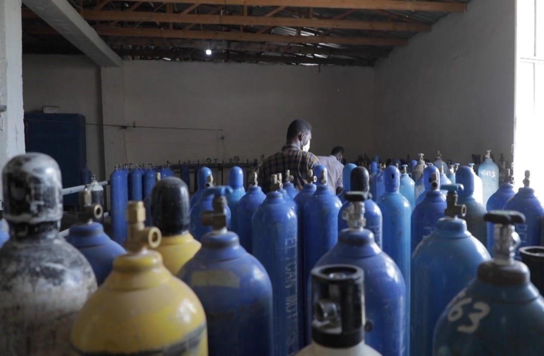 Man inspects oxygen canisters