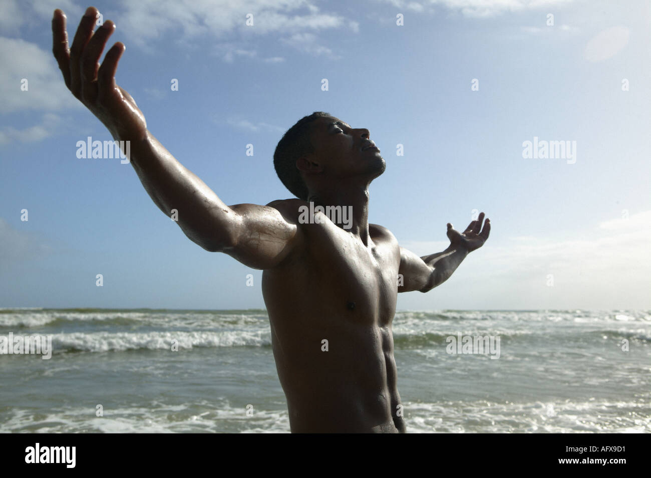 man-with-arms-stretched-out-on-beach-in-sun-AFX9D1.jpg