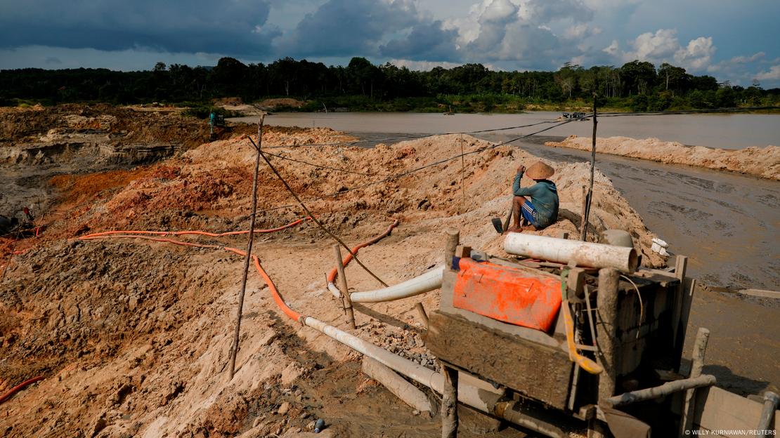 An unlicensed miner takes a break while working in a tin mining area in Toboali, on the southern shores of the island of Bangka, Indonesia,