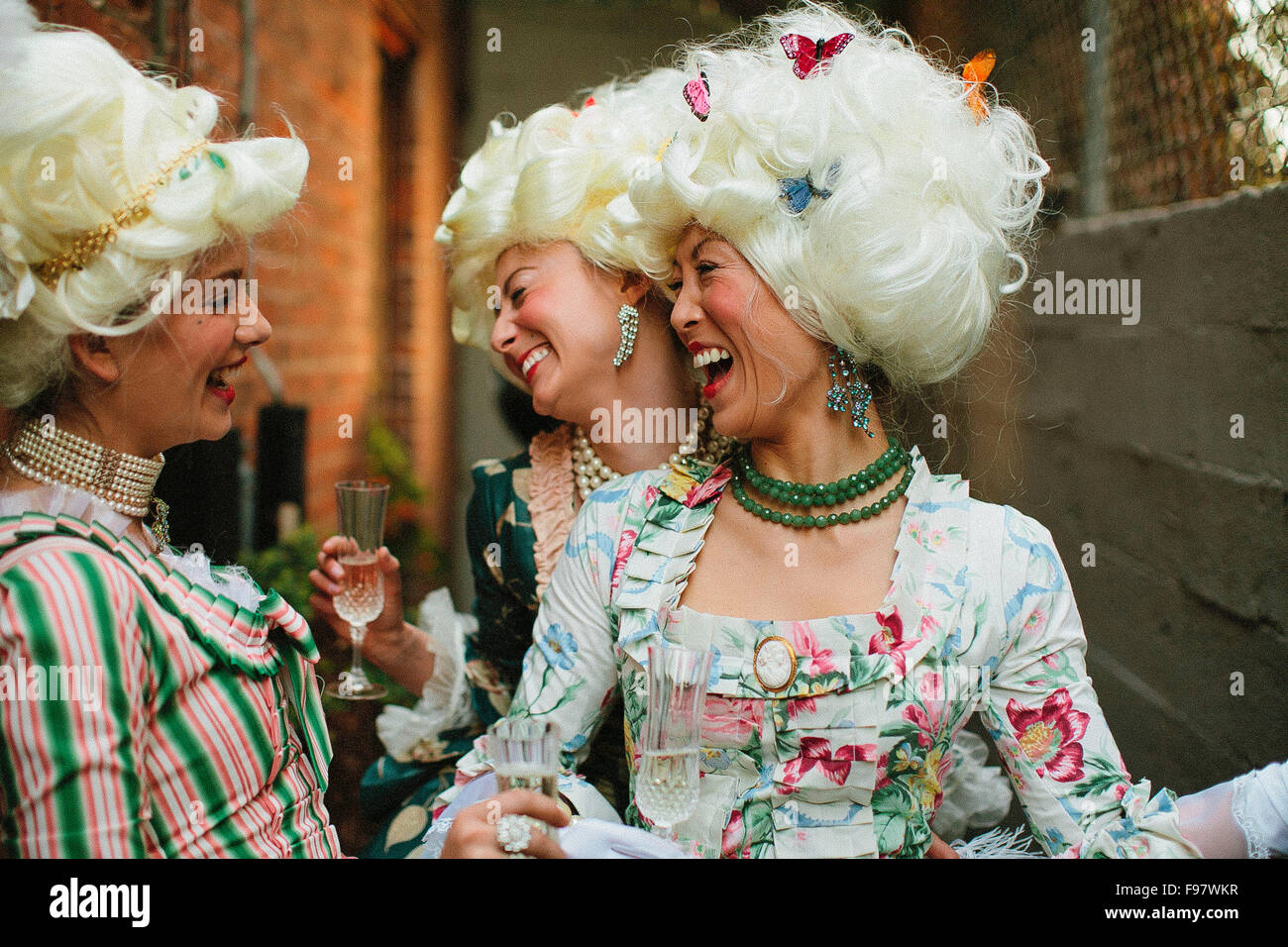 women-laughing-during-victorian-themed-dinner-F97WKR.jpg