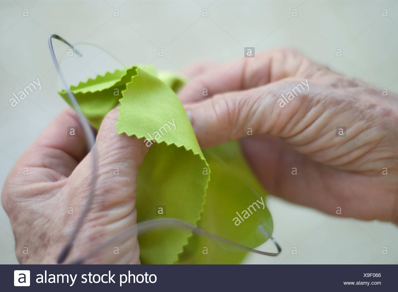old-woman-cleaning-her-glasses-X9F066.jpg