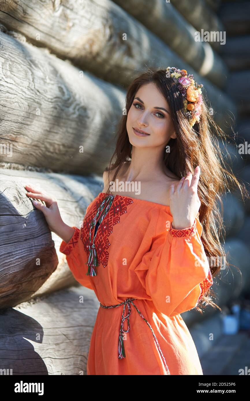 beautiful-slavic-woman-in-an-orange-ethnic-dress-and-a-wreath-of-flowers-on-her-head-beautiful-natural-makeup-portrait-of-a-russian-girl-2D525P6.jpg