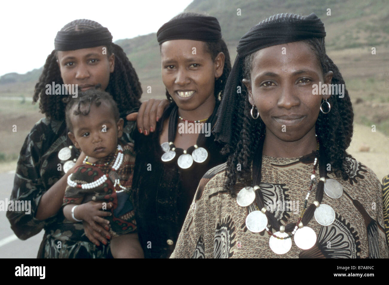 group-of-three-oromo-women-one-of-them-holding-a-toddler-each-wearing-B7A8NC.jpg