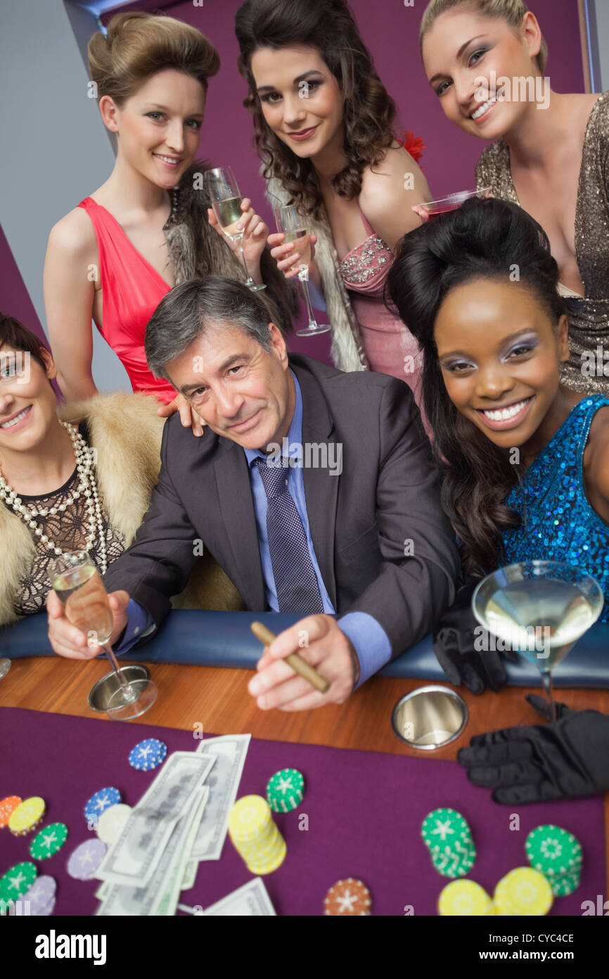 man-surrounded-by-beautiful-women-at-roulette-table-CYC4CE.jpg