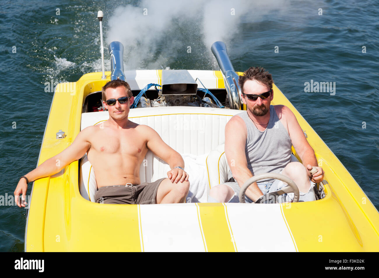 two-guys-in-a-yellow-and-white-speedboat-in-the-sunshine-on-lake-coeur-F3KD2K.jpg