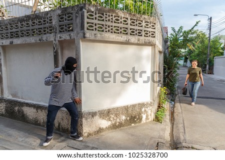 stock-photo-man-wearing-a-hood-conceal-the-face-with-gun-in-hand-and-hiding-in-the-corner-stealing-a-handbag-1025328700.jpg