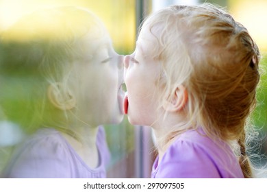 cute-funny-little-girl-licking-260nw-297097505.jpg