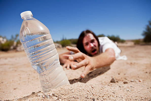 man-in-desert-reaching-for-water-picture-id173256386