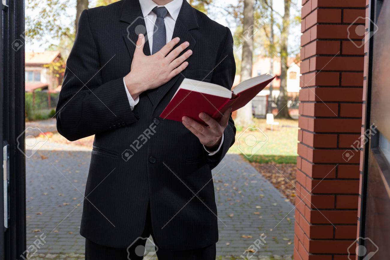 33085241-jehovah-s-witness-standing-at-the-door-and-holding-bible.jpg
