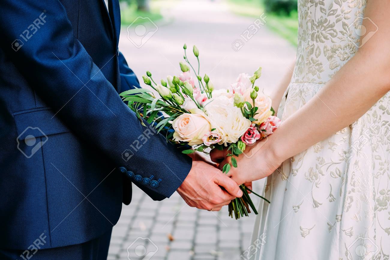 106535897-husband-and-wife-in-blue-suit-and-wedding-dress-getting-married-and-holding-hands.jpg