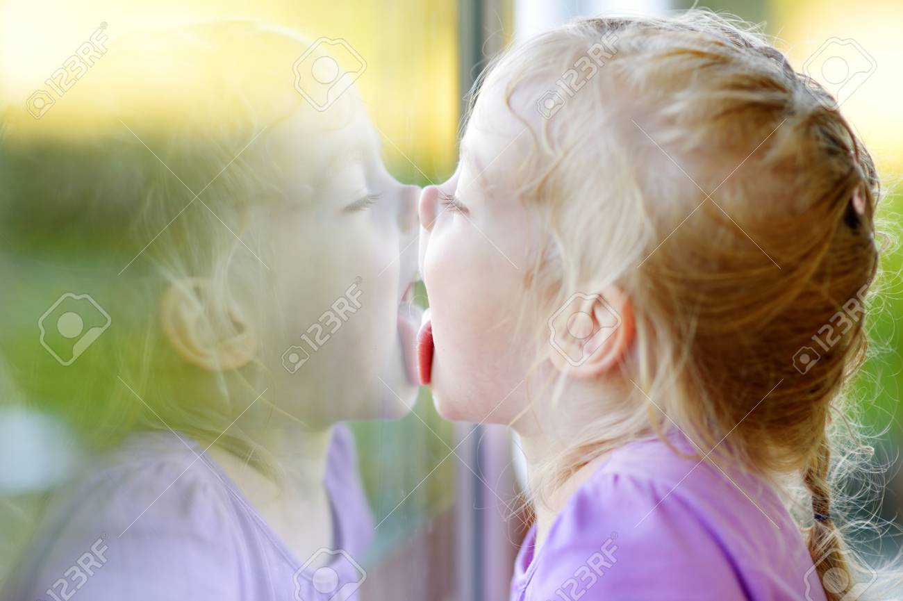 43175565-cute-funny-little-girl-licking-her-reflection-on-a-window-glass.jpg